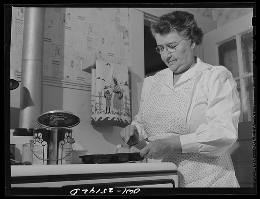 San Augustine, Texas. Mrs. Rushing, the wife of the mayor, greasing a pan preparatory to making cornbread