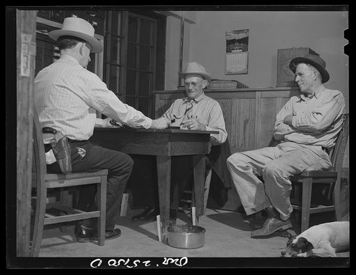 San Augustine, Texas. Lud Behnholder, filling station operator, watching night marshall Jeff Davis and the Justice of the Peace H.L. Armstrong in a domino game