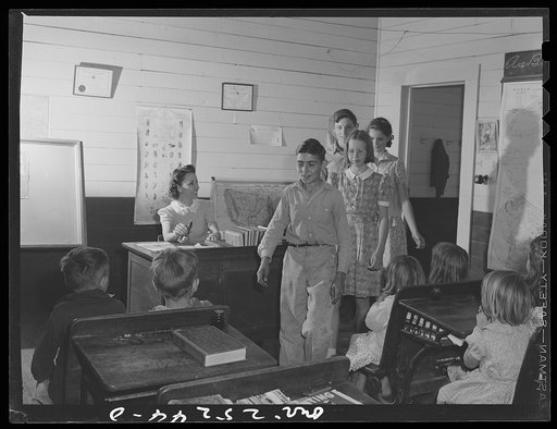 San Augustine, Texas. Rural school children coming into class as the teacher rings the bell