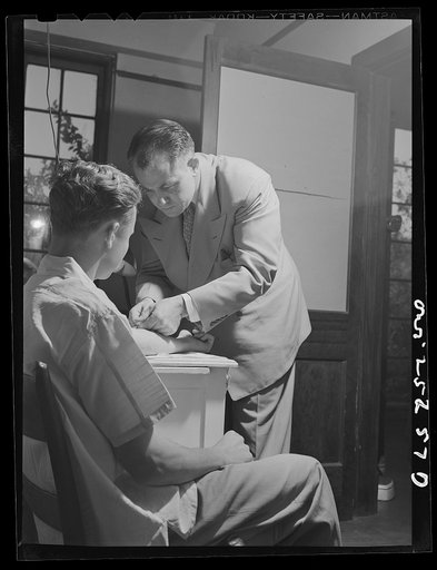 Untitled photo, possibly related to: San Augustine, Texas. Dr. Jones taking the blood pressure of the grocer's boy who has just turned eighteen and is about the be inducted into the Army