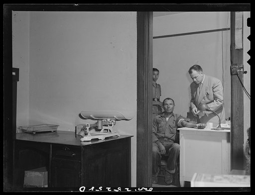 Untitled photo, possibly related to: San Augustine, Texas. Dr. Jones taking the blood pressure of the grocer's boy who has just turned eighteen and is about the be inducted into the Army