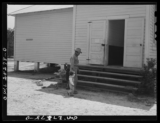 San Augustine County, Texas. A father taking his son to the rural school for typhoid innoculation