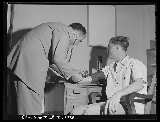 San Augustine, Texas. Dr. Jones taking the blood pressure of the grocer's boy who has just turned eighteen and is about the be inducted into the Army