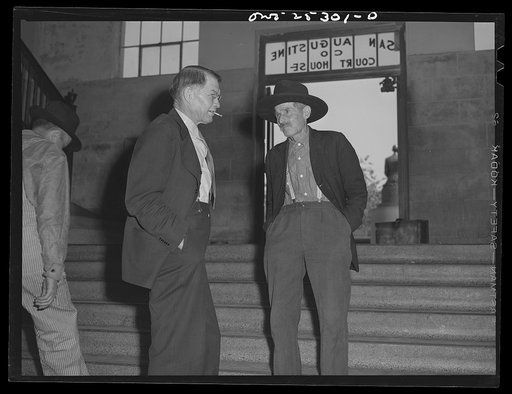 San Augustine, Texas. County Judge Robert Norvell talking with a farmer in the courthouse