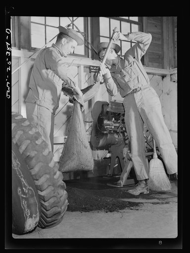 Holabird ordnance depot, Baltimore, Maryland. Soldier sweeping up the buffing dust in the recapping shop which will be turned into the United States Army quartermaster for salvage. Both crude and cured rubber are salvaged as is the Holland paper which covers the surface of the uncured rubber when it