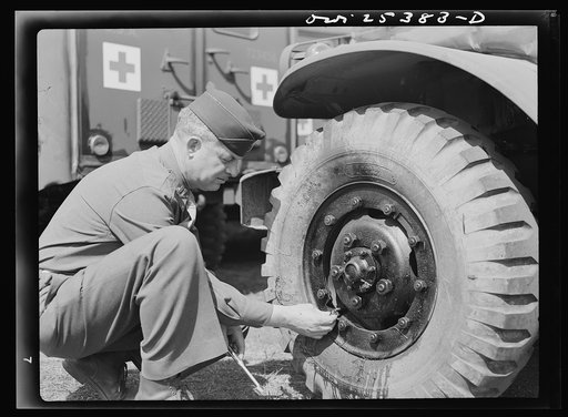 Holabird ordnance depot, Baltimore, Maryland. A careful check is made of air pressure, tire conditions and condition of valves and valve caps before these ambulances are sent overseas
