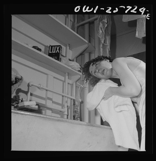 Arlington, Virginia. A girl washing her hair in a laundry tub at Arlington Farms, a residence for women who work in the government for the duration of the war