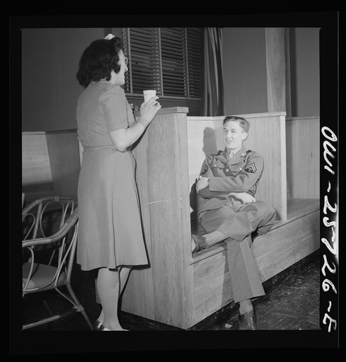 Arlington, Virginia. One of the bi-weekly "open house" dances at Idaho Hall, Arlington Farms, a residence for women who work in the government for the duration of the war. Soldier is seated in one of the date booths in the main lounge