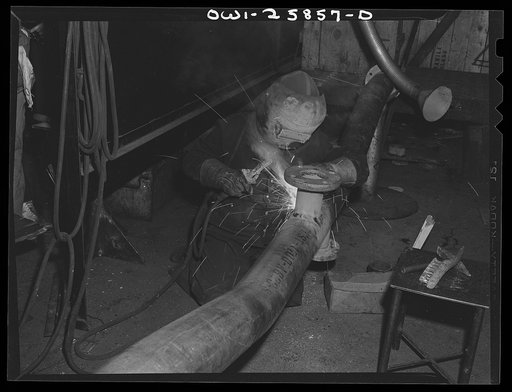 Bethlehem-Fairfield shipyards, Baltimore, Maryland. Welding a flange on a pipe