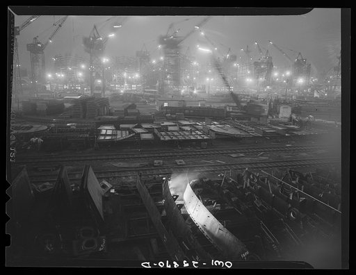 Bethlehem-Fairfield shipyards, Baltimore, Maryland. The shipways at night with a welder in the foreground