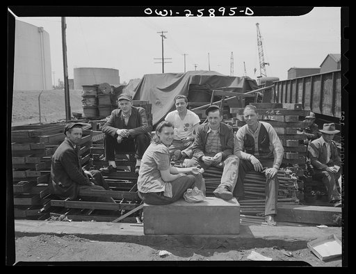 Bethlehem-Fairfield shipyards, Baltimore, Maryland. Woman worker eating lunch with a group of male workers