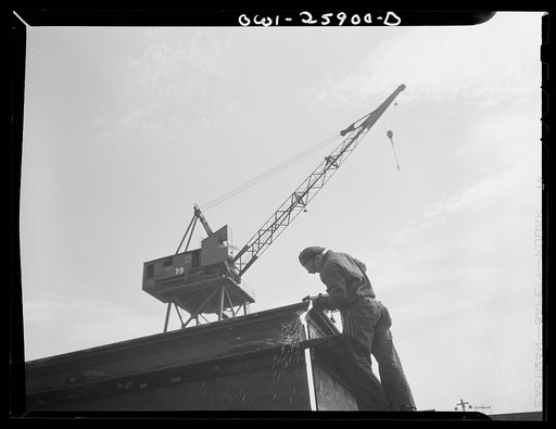 Bethlehem-Fairfield shipyards, Baltimore, Maryland. Welding the corner of steel section, with a crane in the background