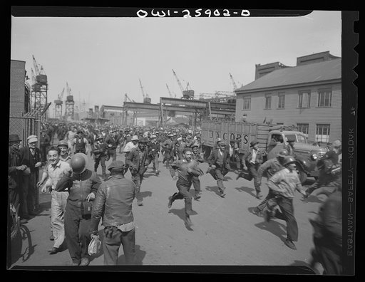 Bethlehem-Fairfield shipyards, Baltimore, Maryland. Workmen running to punch the clock at the end of their shift