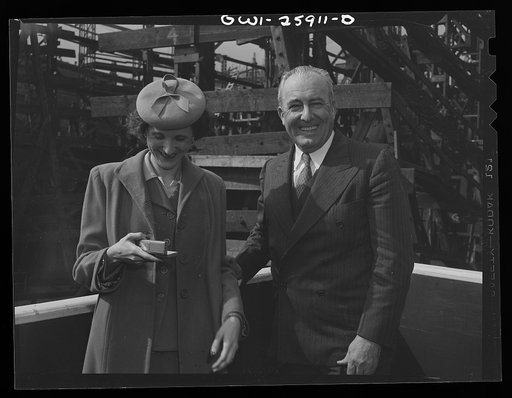 Bethlehem-Fairfield shipyards, Baltimore, Maryland. Jack Willis, vice-president in charge of production of the Bethlehem Fairfield shipyards with the sponsor of a newly-launched ship. The sponsor is looking at a gift given to her as a souvenir at the launching