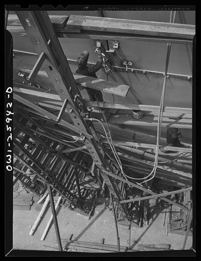 Bethlehem-Fairfield shipyards, Baltimore, Maryland. A welder working on the top part of a ship
