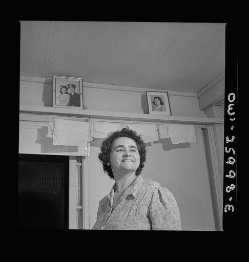Arlington, Virginia. An older resident reading the paper and listening to the radio in her room at Idaho Hall, Arlington Farms, a residence for women who work in the U.S. government for the duration of the war