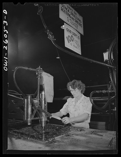 Untitled photo, possibly related to: Bell Aircraft Corporation, Niagara Falls, New York. Stack drilling from a template. The sign in the background shows that the department has a 100% war bond purchase record