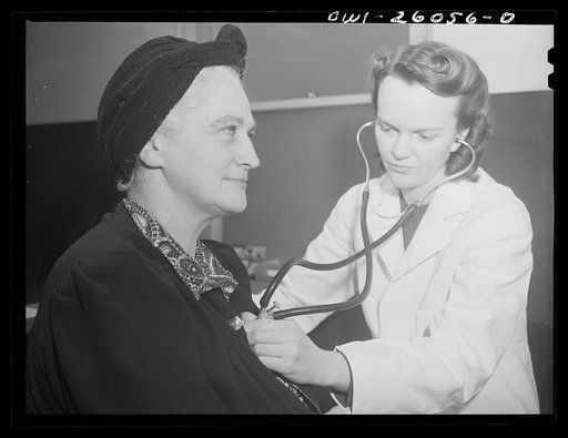 Buffalo, New York. After being interviewed and given an eye test, Mabel Goodwin, forty-five, is examined by a woman doctor at the employment office of the Bell Aircraft plant. She worked in a factory in the last war, and has since been a housewife, and has two children over fourteen