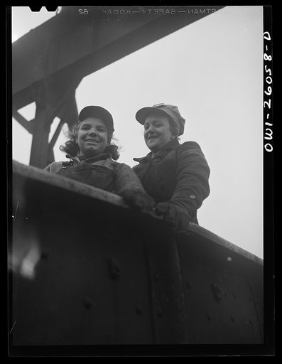 Buffalo, New York. Two "hookers" in a gondola car in the Republic steel yard, pausing after loading a huge crane. Jennie Gravante, on the left, is forty-three, has two sons in the Army, both of whom worked in the plant before the war