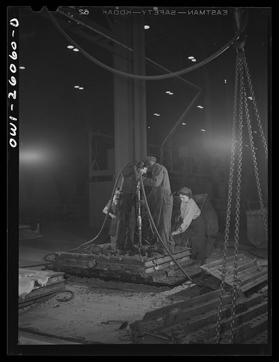 Buffalo, New York. Symington-Gould, makers of tank, ship, and railroad parts. Making mold for armor plates to be tested on proving ground. The flask, or metal frame is placed over the flask, and two men press it down with air hammers