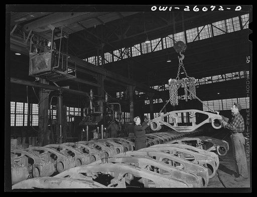 Buffalo, New York. Symington-Gould, makers of tank, ship, and railroad parts. Woman and man chainman loading rough castings of truck trains for railroad cars on a five-ton crane, also operated by a woman