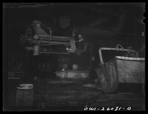 Untitled photo, possibly related to: Buffalo, New York. Symington-Gould, makers of tank, ship, and railroad parts. Sand slinger operated by a woman. Sand is forced onto pattern with air pressure. The operator wears safety goggles and a dust-proof noseguard to protect herself from ricocheting sand an
