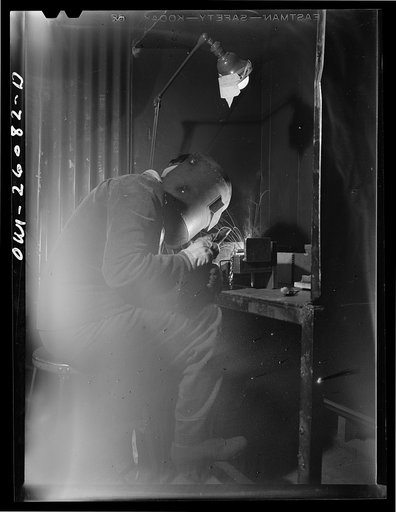 Untitled photo, possibly related to: Bell Aircraft Corporation, Niagara Falls, New York. Woman welder who has been welding the ejection chutes of fifty callibre machine guns