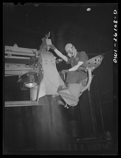 Untitled photo, possibly related to: Buffalo, New York. Symington-Gould, makers of tank, ship and railroad parts. Sand slinger operated by a woman. Sand is forced onto pattern with air pressure. The operator wears safety goggles and a dust-proof noseguard to protect herself from ricocheting sand and