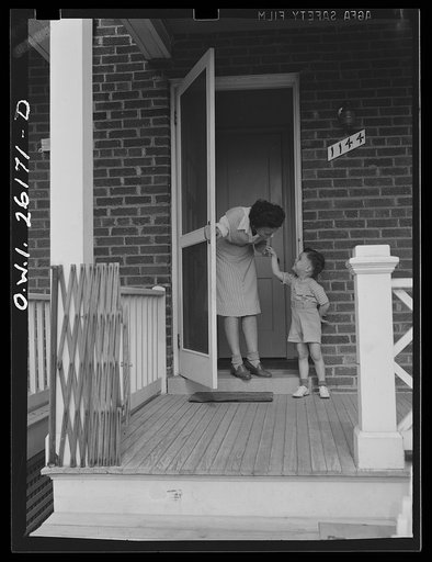 Washington, D.C. A day nursery for pre-school children of mothers engaged in war work, operated under the supervision of the District of Columbia Health Department by Mrs. Leroy Bonbrest, at her home at 1144 Branch Avenue, S.E. A child bidding Mrs. Bonbrest good-bye