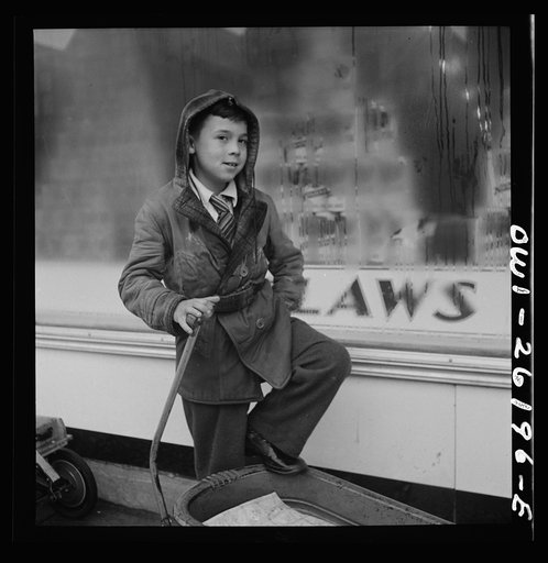 Buffalo, New York. Peter Grimm, age ten, waiting with his wagon outside Loblaw's grocery store for customers to ask him to deliver their groceries. This was a rainy day with few customers. Sometimes Peter makes as much as three dollars on a Saturday. He pays for all his school supplies and much of h