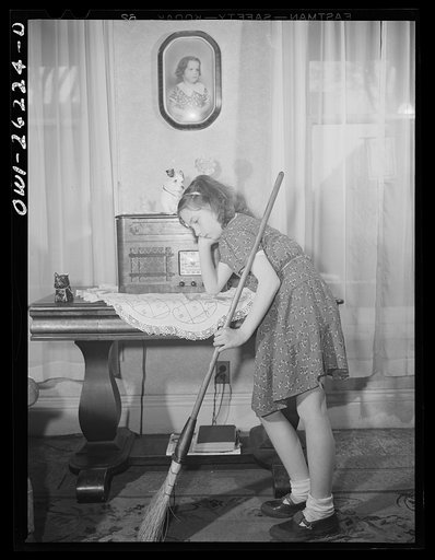 Buffalo, New York. Beverly Ann, eleven, the oldest of the six Grimm children, pausing to listen to a radio program in the midest of sweeping the front room. Her mother, a twenty-six year old widow, is a crane operator at Pratt and Letchworth