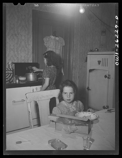 Untitled photo, possibly related to: Buffalo, New York. Beverly Ann Grimm, eleven, serving an omelette for Saturday lunch for her sisters and herself, while Pasty looks on. Their mother, a twenty-six year old widow, is a crane operator at Pratt and Letchworth