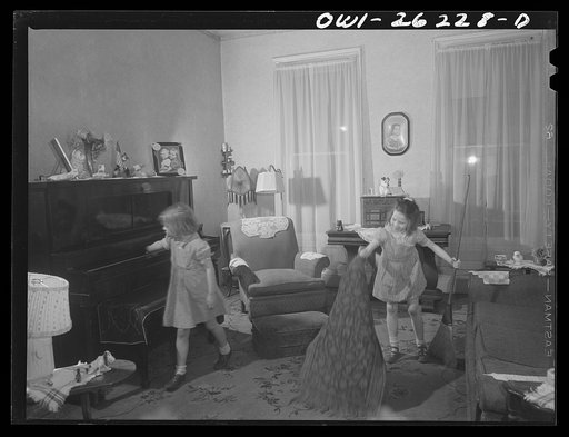 Buffalo, New York. Patsy Grimm, age six, dusting and Mary Grimm, eight, sweeping in the front room. Their mother, a twenty-six year old widow, is a crane operator at Pratt and Letchworth