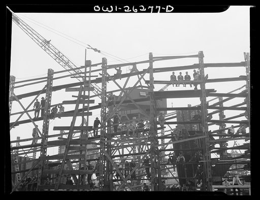Bethlehem-Fairfield shipyards, Baltimore, Maryland. Workmen sitting on the scaffold watching the launching ceremony