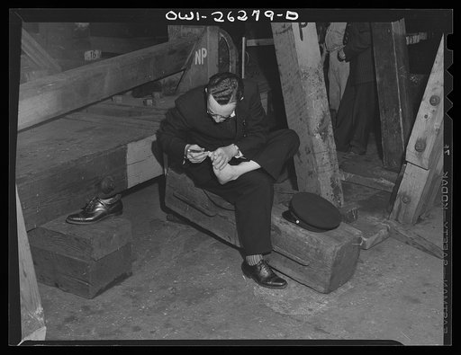 Bethlehem-Fairfield shipyards, Baltimore, Maryland. Coast Guard watchman working on an ingrown toe nail