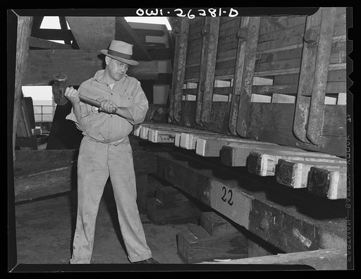 Bethlehem-Fairfield shipyards, Baltimore, Maryland. Preparations for launching a ship. Driving wedges to lift the ship from the keel blocks