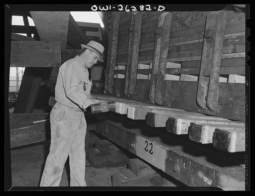 Bethlehem-Fairfield shipyards, Baltimore, Maryland. Preparations for launching a ship. Driving wedges to lift the ship from the keel blocks