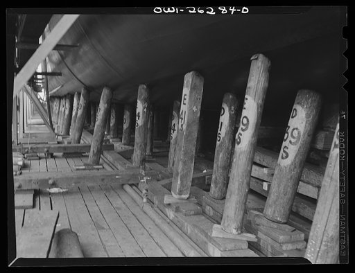 Bethlehem-Fairfield shipyards, Baltimore, Maryland. Preparations for launching a ship. General view of poppins underneath the ship showing numbers