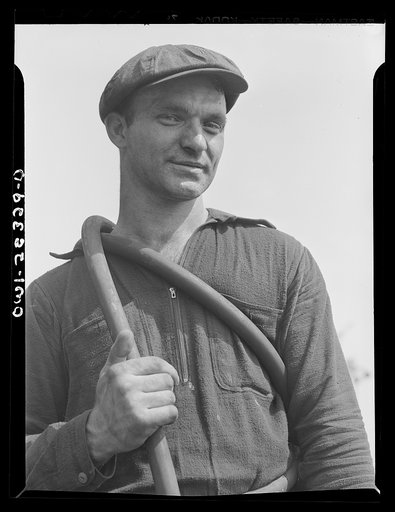 Bethlehem-Fairfield shipyards, Baltimore, Maryland. Worker carrying a rubber hose