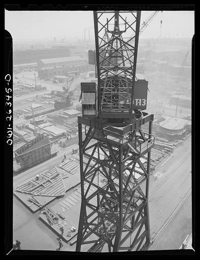 Bethlehem-Fairfield shipyards, Baltimore, Maryland. Looking down on crane operator in the control room
