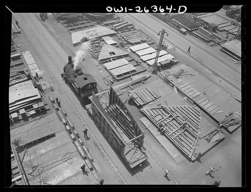 Bethlehem-Fairfield shipyards, Baltimore, Maryland. Locomotive pulling a steel section on a flatcar