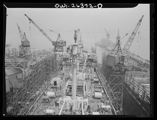 Bethlehem-Fairfield shipyards, Baltimore, Maryland. Nearly completed ship, with fitting docks in the background