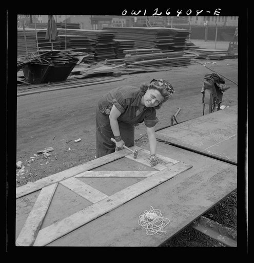 Bethlehem-Fairfield shipyards, Baltimore, Maryland. Punching down the wooden templates to mark out the steel