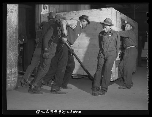 Chicago, Illinois. Freight handlers moving a very heavy piece of freight at the United States Army consolidating station