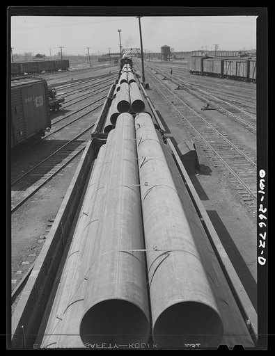 Bensenville, Illinois. Pipe for the "Big Inch" line, being switched at the Bensenville Yard for transfer to the eastern railroads by the Chicago, Milwaukee, Saint Paul and Pacific Railroad