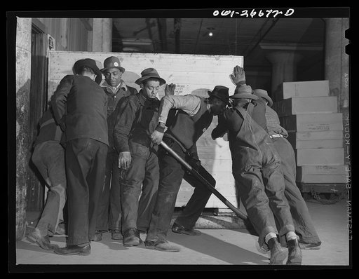 Chicago, Illinois. Freight handlers moving a very heavy piece of freight at the United States Army consolidating station