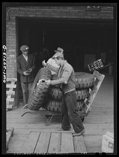 Untitled photo, possibly related to: Chicago, Illinois. Checking tires that have just been unloaded from a truck at the United States Army consolidating station