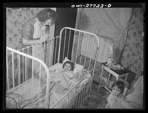 Buffalo, New York. Mona, two, and Carol Grimm, five, being put to bed by their foster mother Mrs. Hehr, with whom they live during the week. Sundays they go home to their mother, who is a twenty-six year old widow with six children under twelve. She works as a crane operator at Pratt and Letchworth