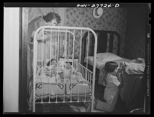 Untitled photo, possibly related to: Buffalo, New York. Mona, two, and Carol Grimm, five, being put to bed by their foster mother Mrs. Hehr, with whom they live during the week. Sundays they go home to their mother, who is a twenty-six year old widow with six children under twelve. She works as a cr