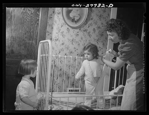 Buffalo, New York. Mona, two, and Carol Grimm, five, being put to bed by their foster mother Mrs. Hehr, with whom they live during the week. Sundays they go home to their mother who is a twenty-six year old widow with six children under twelve. She works as a crane operator at Pratt and Letchworth